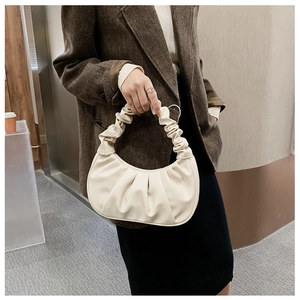 Detail of cream pleated hobo bag with cloud-like texture and matte leather finish