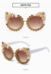 Detailed view of cat eye sunglasses with rhinestones, floral decor and bee accents