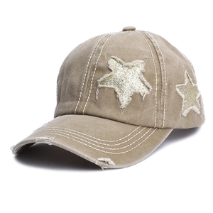 Detailed view of the distressed khaki baseball cap with silver glitter star patches