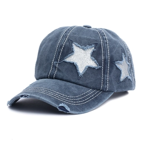 Detailed close-up of distressed denim baseball cap featuring silver glitter star patches