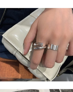 Close-up of sculptural irregular wide silver rings worn on hand for a modern style