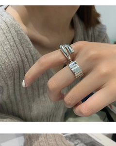 Close-up of minimalist silver irregular geometric rings on a model's hand