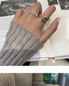 Close-up of stylish silver geometric rings worn by a model with lifestyle background