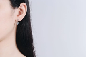 Close-up of S925 sterling silver drop earring with 1 carat moissanite on female model