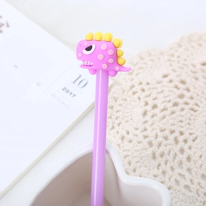 Pink cartoon dinosaur gel pen with silicone topper on a cozy desk setting