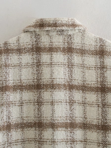 Gros plan sur le tissu à carreaux marron épais et les coutures du col de la chemise