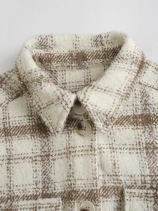 Gros plan détaillé sur la texture du tissu à carreaux brossé et boutons de la chemise beige