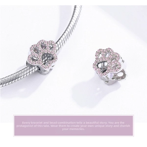 Macro detail of S925 sterling silver cat paw charm with pink zircon stones on bracelet