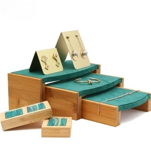 Macro shot of tiered bamboo jewelry stand with emerald green velvet for rings and earrings