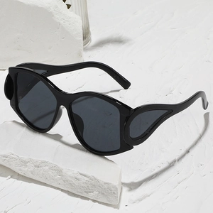 Punk style oversized black sunglasses with unique wing hollow design on a stone base