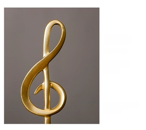 Close-up of golden resin G-clef ornament featuring high-quality smooth metallic texture