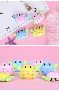 Detail view of colorful cartoon crab plastic toys for kids in yellow, pink and blue