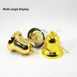 Close-up of three festive gold and silver bells with cords on a white background