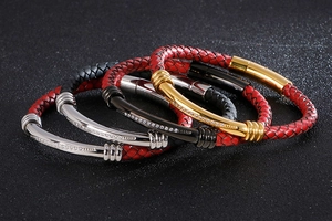 Close-up of woven leather bracelets with gold and silver diamond-set metal magnetic clasps