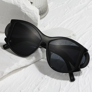 Modern punk style oversized black polarized sunglasses on textured stone background