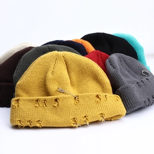Distressed knit beanies with metal rings and pins in various colors for street style