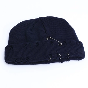 Detail view of dark blue distressed beanie with silver safety pin and metal rings