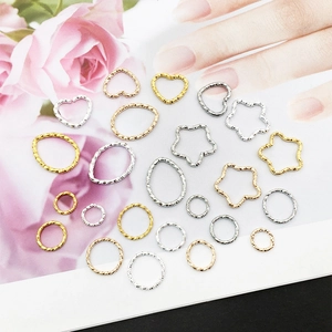 Macro detail of geometric heart star and round alloy jewelry charms with hammered texture