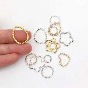 Detailed view of textured gold and silver geometric DIY jewelry charms in various shapes