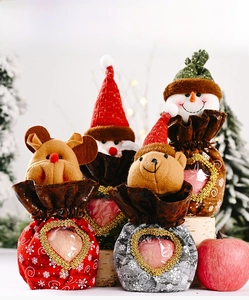 Detail of Christmas gift bags featuring reindeer and Santa with clear heart windows