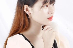 Vue détaillée de boucles d'oreilles nœuds en acier titane doré rose sur un mannequin