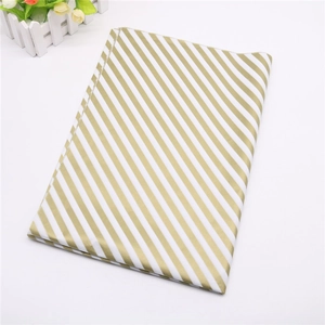 Close-up of premium wrapping paper with elegant gold and white diagonal stripes