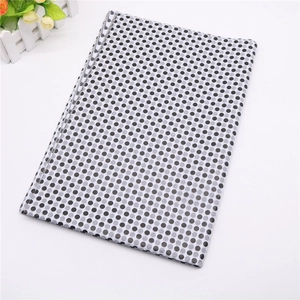 Detail of thin gift wrapping tissue paper with black polka dot patterns on white background