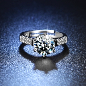 Macro shot of six-prong solitaire ring with side stones and S925 engraved on inner band