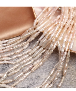 Macro detail of long baroque toothpick pearls with luster on silk and shell tray