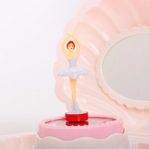 Detail view of pink shell music box featuring a rotating ballerina and interior mirror