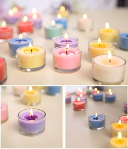 Detailed close-up of colorful paraffin wax tea lights in glass cups for home decor