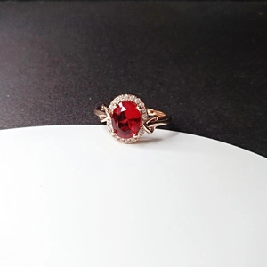Macro shot of halo set ruby ring with 18k rose gold band and intricate hollow design