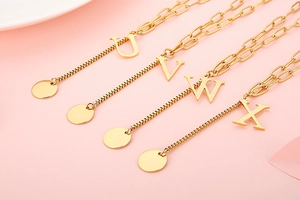 Detail of gold letter pendants U V W X on mixed link stainless steel chain necklaces