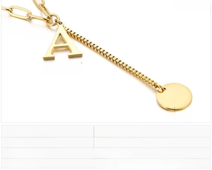 Detail of stainless steel necklace with gold letter A pendant and round disc charms