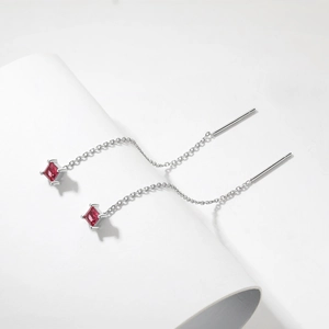 Detail view of S925 silver chain earrings with square red gemstone on white background
