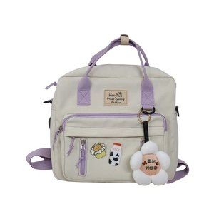 Detail of beige and purple canvas backpack featuring multiple pockets and cute badges