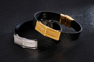 Close-up of black braided leather bracelets with gold and silver stainless steel buckles