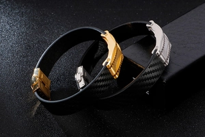 Detail of men's leather bracelets with gold and silver carbon fiber clasp closures