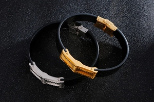 Close-up of black braided leather bracelets with gold and silver geometric steel buckles