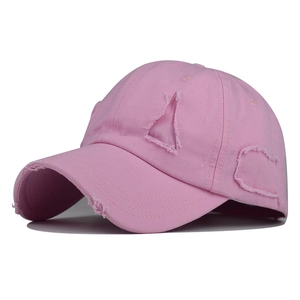 Detailed close-up of a pink distressed cotton baseball cap with ripped brim and vintage style