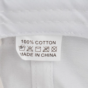 Macro detail of washing label showing 100% cotton material and stitching on the white cap