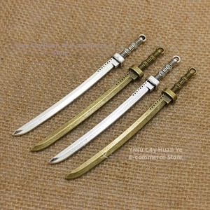 Detail van vintage mini katana zwaard bedeltjes in antiek zilver en brons voor sieraden