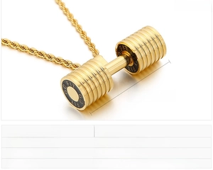Macro shot of gold dumbbell pendant with GO FIT engraving and woven twist chain detail