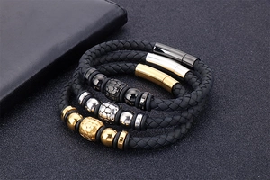 Detailed close-up of three braided leather bracelets with gold, silver, and black clasps