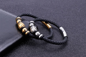 Close-up of braided black leather bracelets with gold and silver magnetic steel clasps