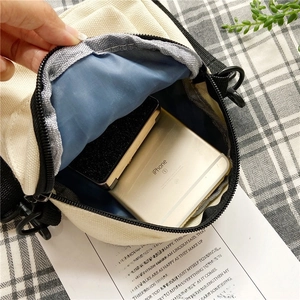 Close-up showing the interior storage capacity and blue lining of the beige canvas bag