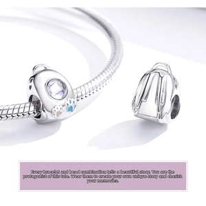 Macro detail of S925 silver backpack charm with pink and blue enamel paw prints