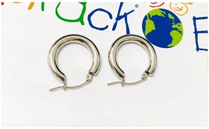 Macro shot of silver stainless steel hoop earrings with polished metal texture and clasp