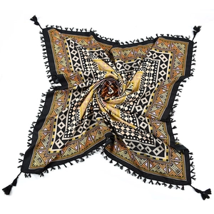 Detail of bohemian jacquard square scarf with ethnic geometric patterns and black tassels