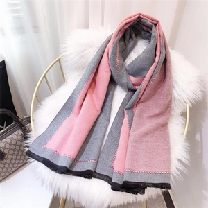 Detail of pink and gray two-tone cashmere-like scarf with fringe and geometric edges